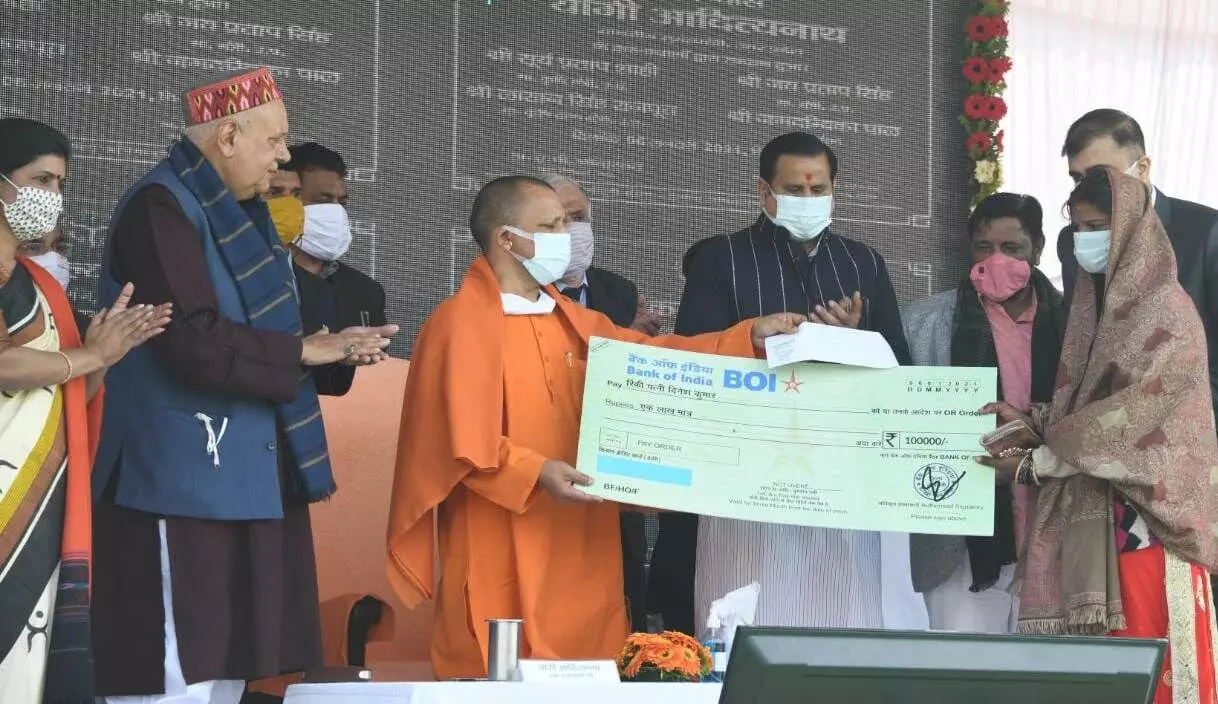 In this image we see the cm(yogi g ) of up to give the check of 1 lakh to the lady through UP Kisan Kalyan Mission.
