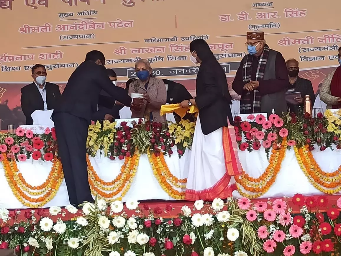 कार्यक्रम के दौरान राज्यपाल आनंदीबेन पटेल को भेंट करते कृषि विश्वविद्यालय के छात्र।