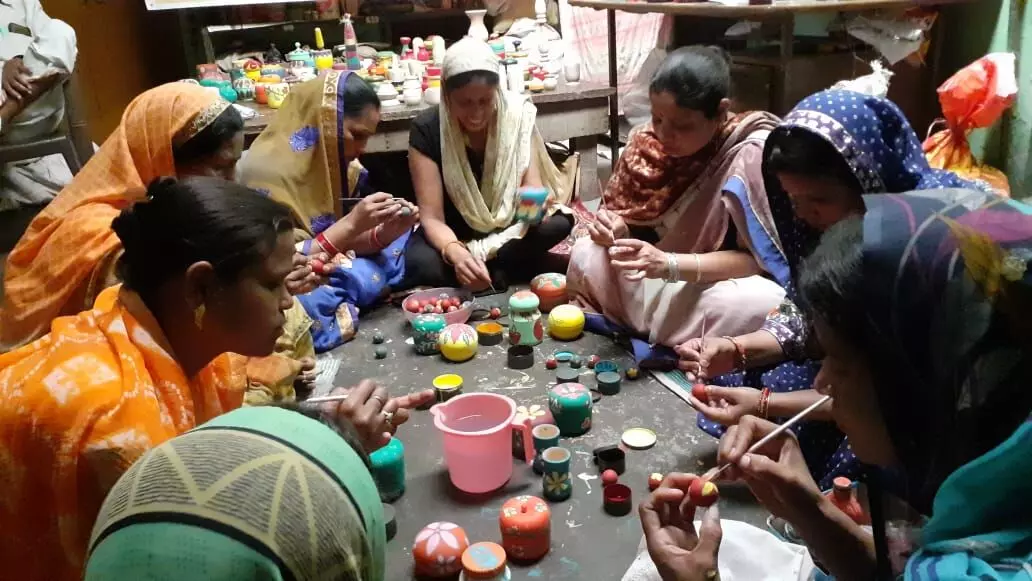 साथी महिला कारीगरों के साथ खिलौने को पेंट करती अर्चना देवी बिल्कुल मध्य में (फोटो- आनंद कुमार) साथी महिला कारीगरों के साथ खिलौने को पेंट करती अर्चना देवी बिल्कुल मध्य में (फोटो- आनंद कुमार)