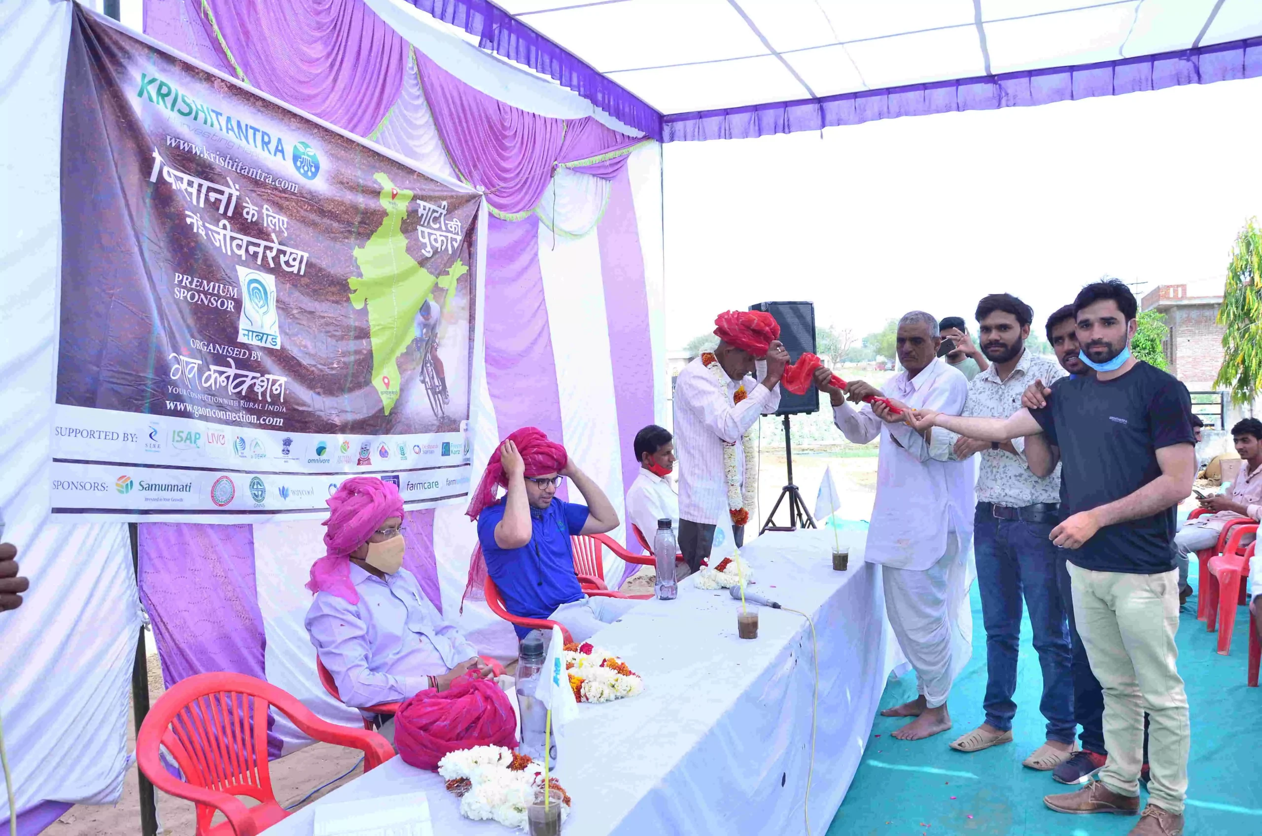 जयपुर में आयोजित समारोह में अथितियों को परापंरागत पगड़ी बांधकर स्वागत करते स्थानीय लोग। फोटो- गांव कनेेक्शन