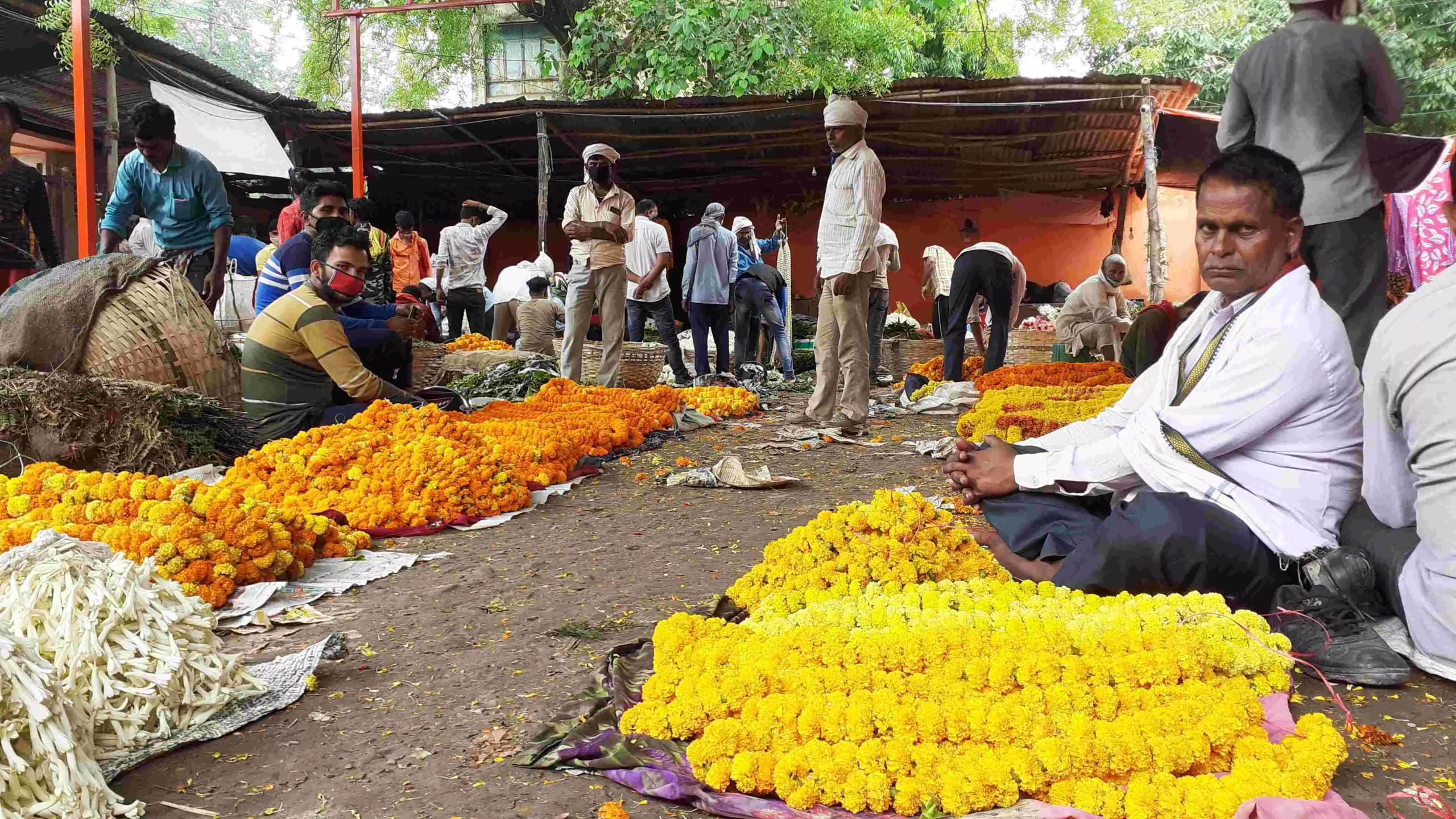 वाराणसी की फूल मंडी में ग्राहकों का इंतजार करते माली। फोटो- आनंद कुमार