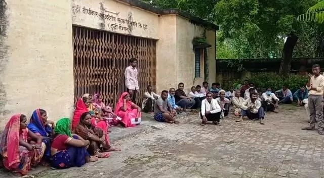 यूपी के सोनभद्र में यूरिया के लिए एक समिति के बाहर इंतजार करते किसान
