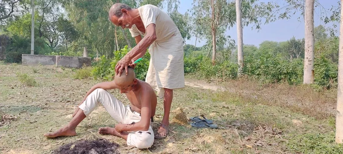 मृतक किसान अनिल कुमार सिंह के परिजन सीतापुर के नैमिषारण्य में क्रिया कर्म करते हुए। फोटो- मोहित शुक्ला
