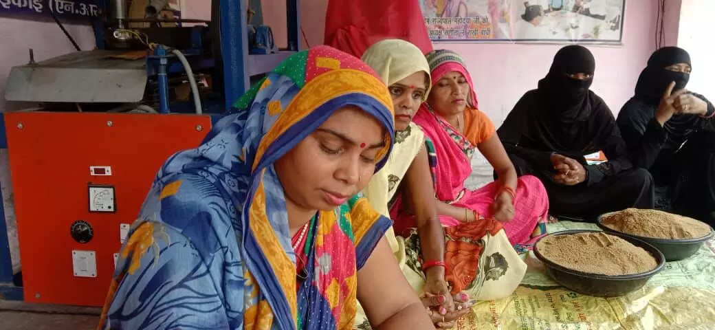 The women deftly scoop up katoris of the masalas and put them into packets. The women deftly scoop up katoris of the masalas and put them into packets.