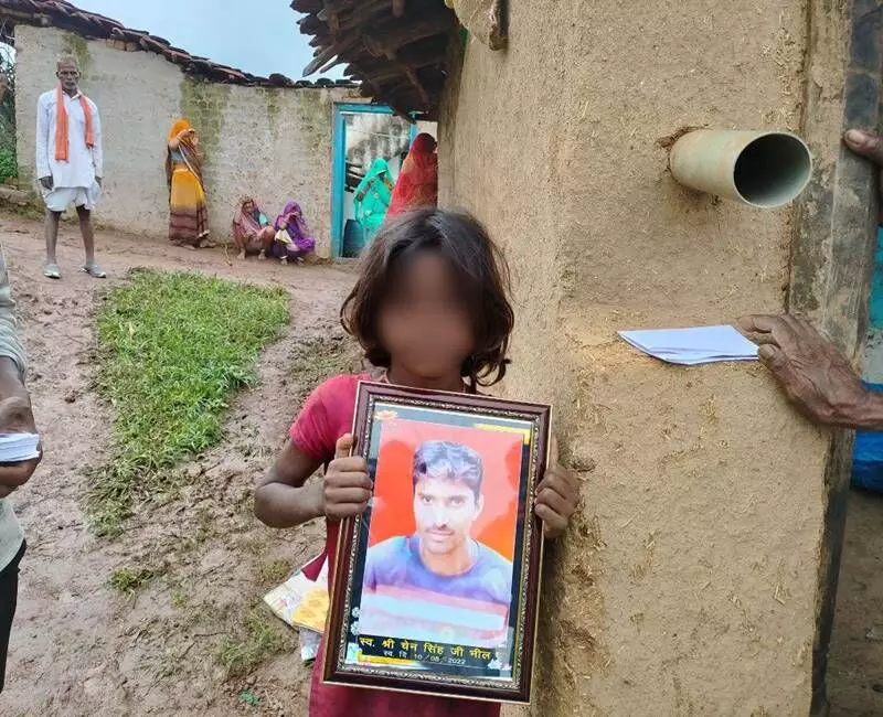 The deceased tribal residents daughter holding her fathers photograph. The deceased tribal residents daughter holding her fathers photograph.
