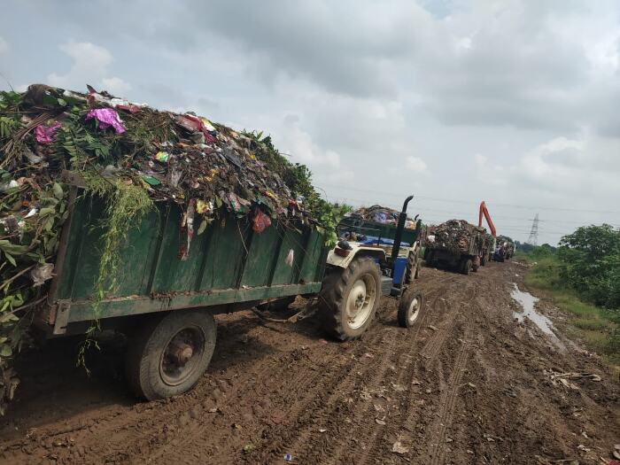 Open tractors transporting Meerut's mixed solid waste to Ganwri village for dumping