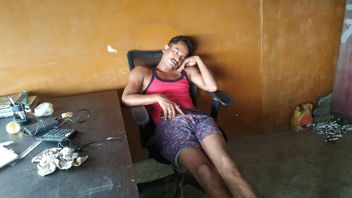 Abrar Ahmed, the scrap shop owner, caught sleeping on duty as there is no work for him these days
